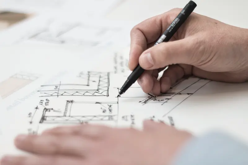 A hand drawing technical details on a blueprint